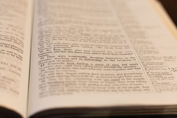 A Bible lay open to Acts 2, where thousands were baptized and added to the church on the Day of Pentecost.