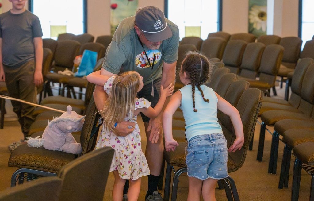 Bud Gothmann, a CityLight elder, welcomes kids to the Vacation Bible School family groups.