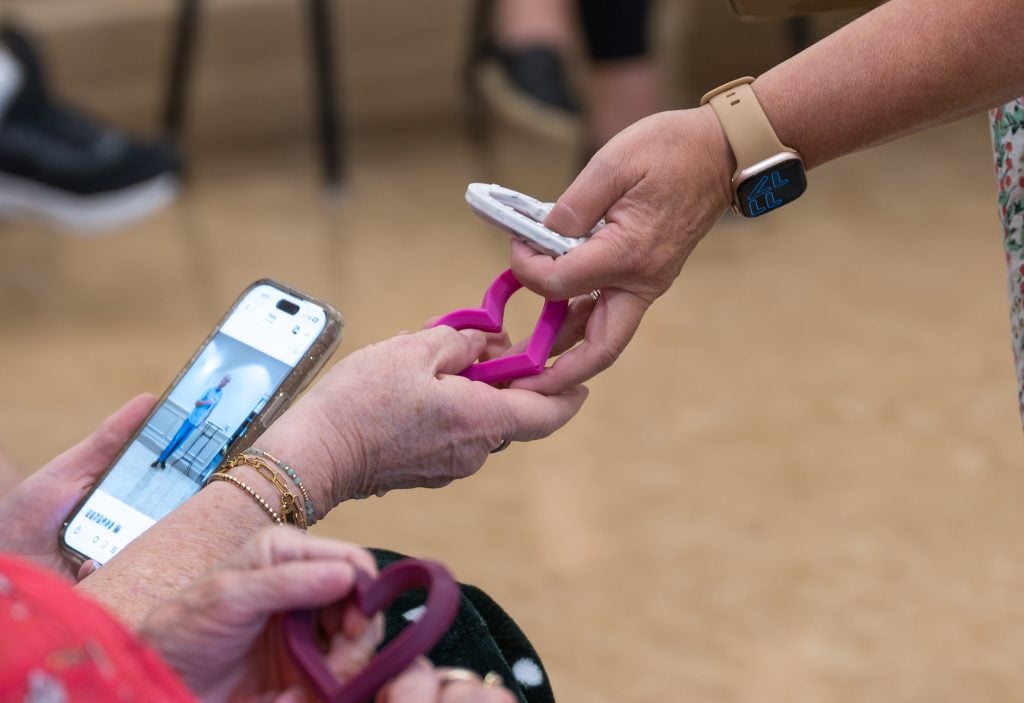 A member of the Sunny Day Club staff hands a plastic heart to a member after a devotional.