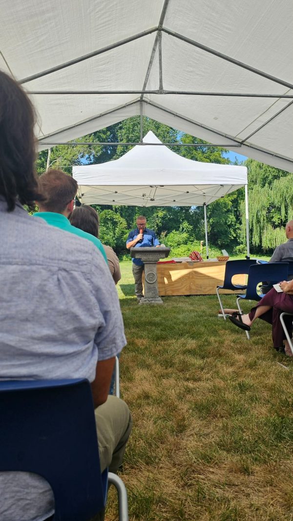 Manuel Florescu preachers under a tent on the Troy church property after the building was destroyed.
