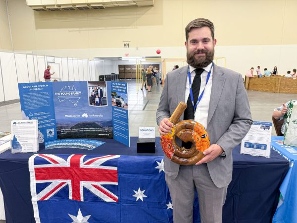 Andrew Young poses with a wooden spiral didgeridoo from Australia in front of his booth at PTP.